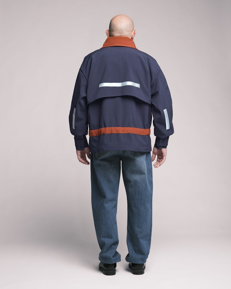 Dos de la veste navy et orange avec bande réfléchissante