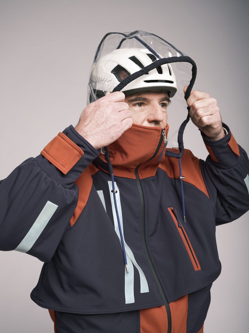 Portrait capuche relevée sur casque, veste orange et navy